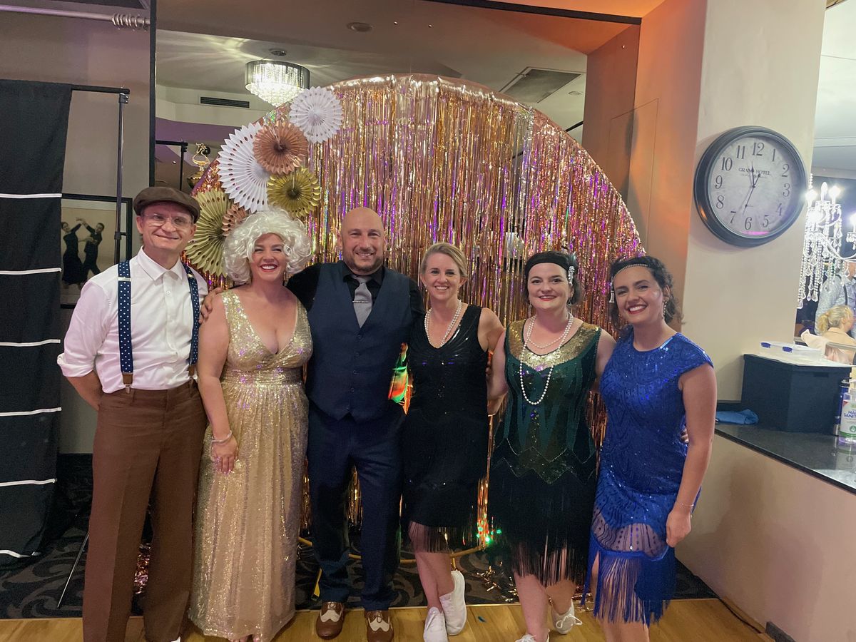 A group in 1920s-style evening dress at a themed social night.